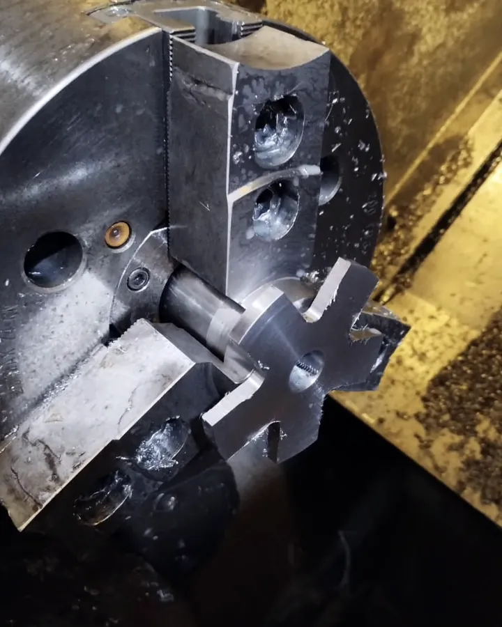Pieza en el plato de un torno CNC durante el mecanizado